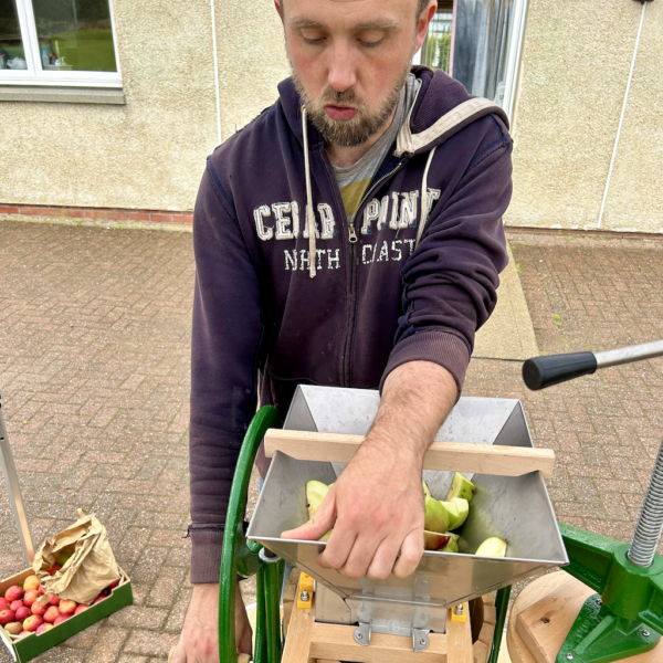 Simon using the apple press at our apple pressing event in Brodick.